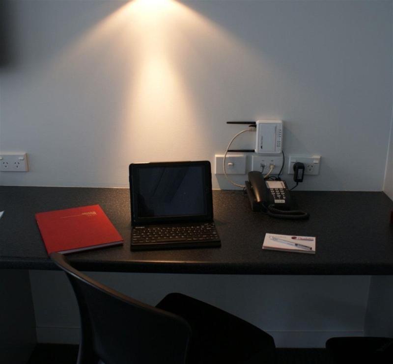 موتيل نيو بلايموث لودج بوكيكورا موتور المظهر الخارجي الصورة A typical hotel room with a phone, a laptop and a book